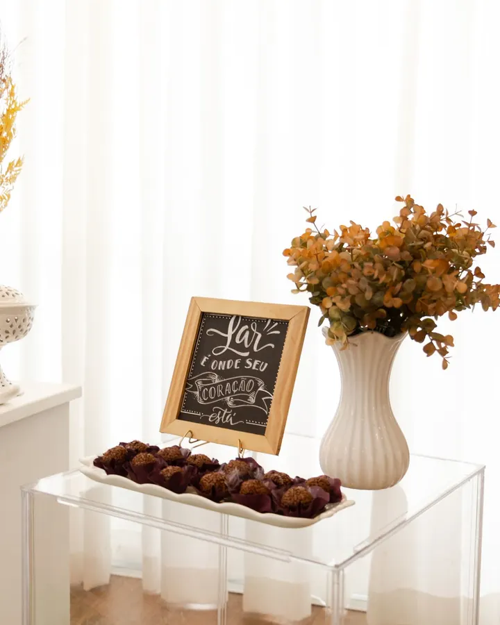 Mesa de acrílico com quadro de giz e vaso de flores