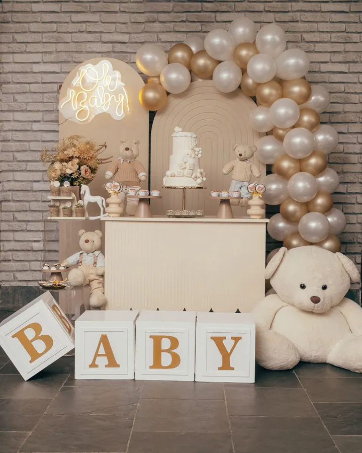 Kit chá de bebê com arco de balões dourados, letreiro neon, bolo, cubos BABY e ursos de pelúcia