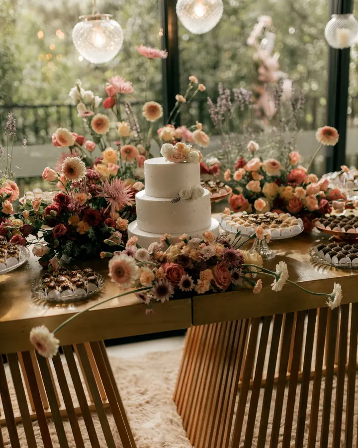 Mesa ripada com bolo branco e flores do campo