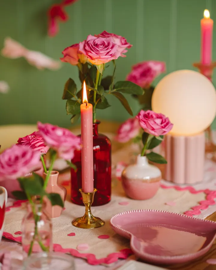 Mesa rosa com velas e rosas