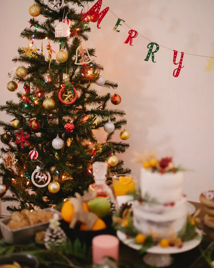 Árvore de Natal ao lado da mesa com bolo e frutas